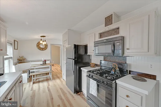 a kitchen with white cabinets and appliances