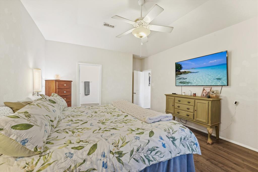 3801 Surf Street Denton, TX 76208 - Photo 20 of 29 Bedroom featuring dark wood-style flooring, ceiling fan, and connected bathroom