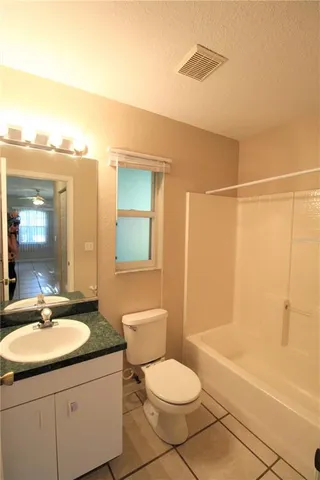 a bathroom with a granite countertop sink toilet a mirror and shower