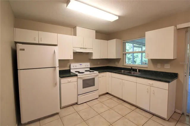 a kitchen with white cabinets and white appliances