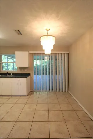 an empty room with closet and a chandelier fan