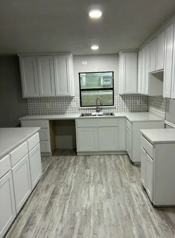 a kitchen with sink cabinets and wooden floor