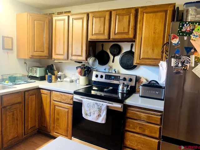 a kitchen with stainless steel appliances granite countertop a refrigerator a sink and a stove