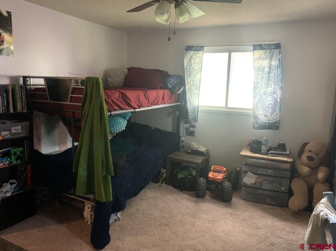 1128 Montana Way Nucla, CO 81424 - Photo 22 of 30 a bedroom with a bed and a chandelier