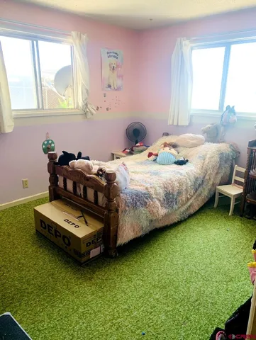 a bedroom with bed and windows