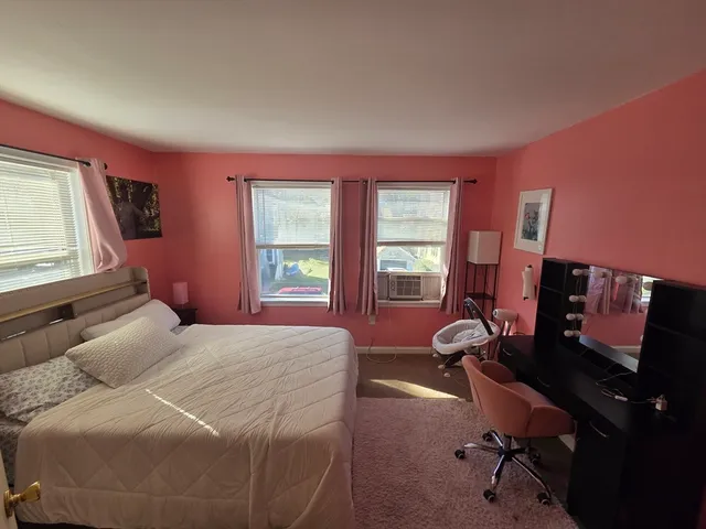 a bedroom with a bed desk and chair