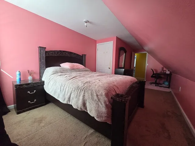 a spacious bedroom with a bed and a dresser