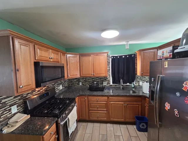 a kitchen with stainless steel appliances granite countertop a sink stove and cabinets