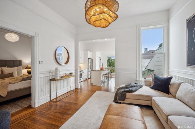 a kitchen with stainless steel appliances kitchen island granite countertop a stove a refrigerator a dining table and chairs with wooden floor