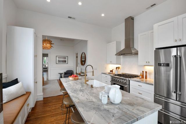 a kitchen with stainless steel appliances granite countertop a stove refrigerator and cabinets