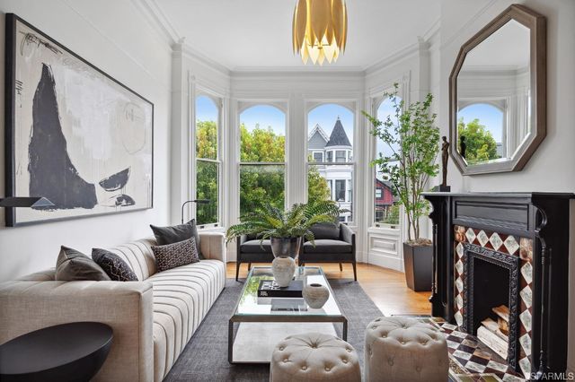 a living room with furniture a fireplace and a large mirror next to a window