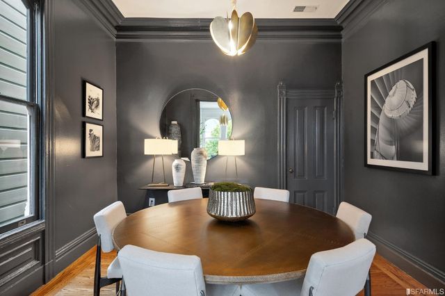 a view of a dining room with furniture a chandelier and wooden floor