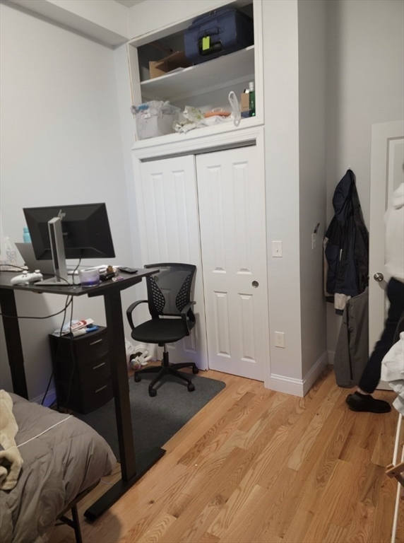 83 Highland Street, Unit 1 Boston, MA 02119 - Photo 7 of 9 a view of a workspace with furniture and wooden floor