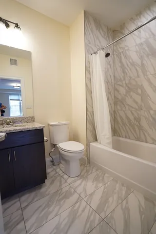 a bathroom with a sink a toilet a mirror and shower