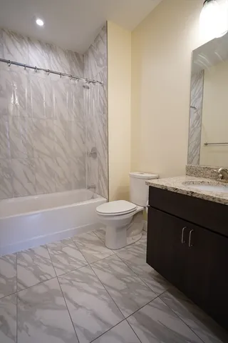 a bathroom with a granite countertop sink toilet and shower