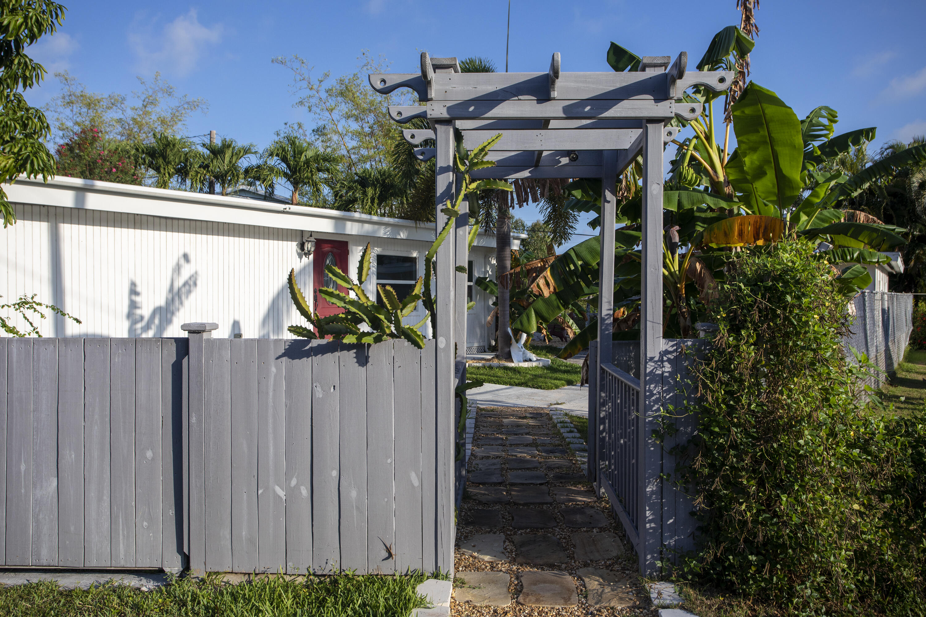a view of a house with a small yard and a wooden fence