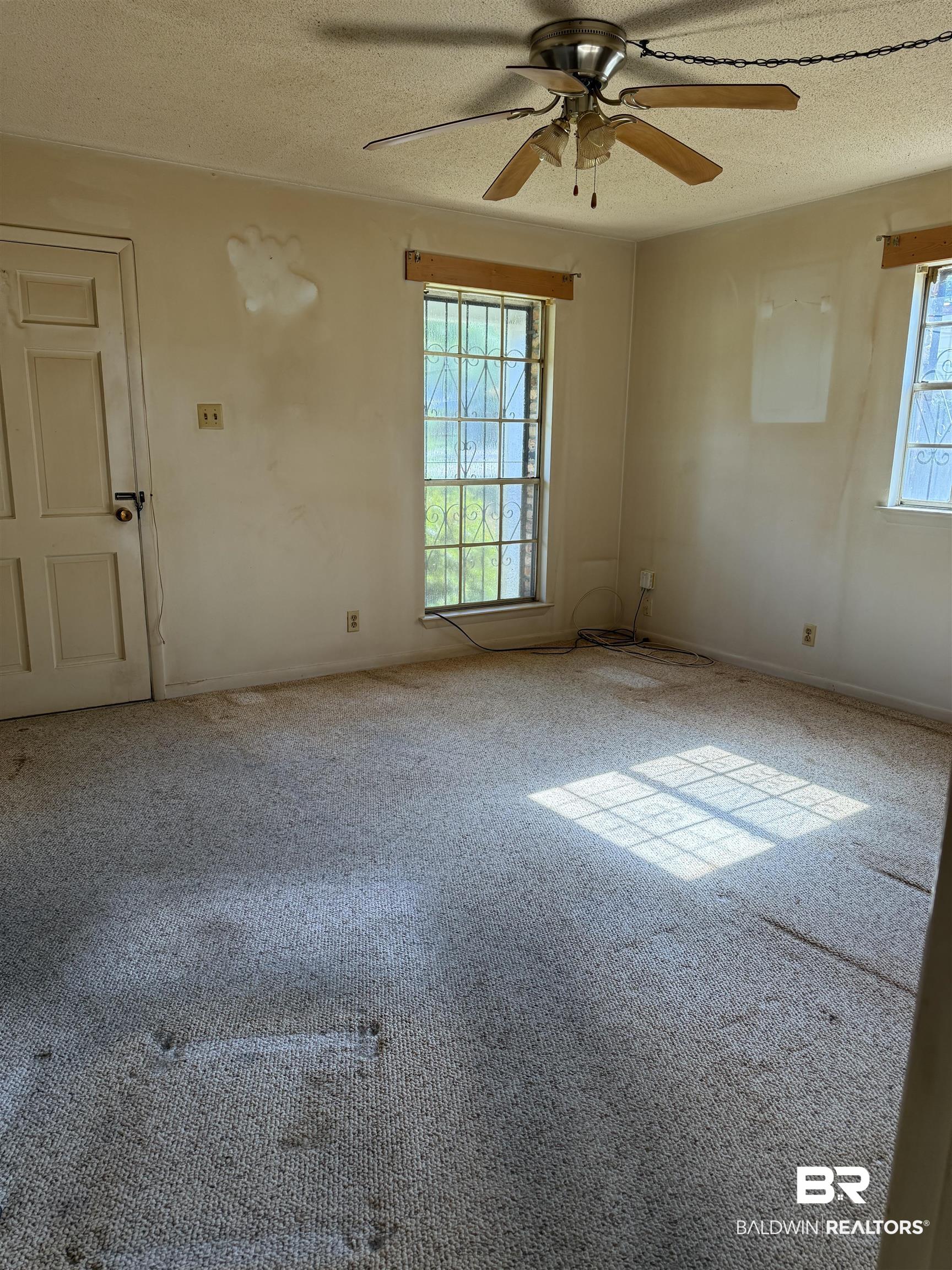 607 West Lee Street Mobile, AL 36611 - Photo 6 of 11 Unfurnished room with carpet floors, ceiling fan, and a textured ceiling
