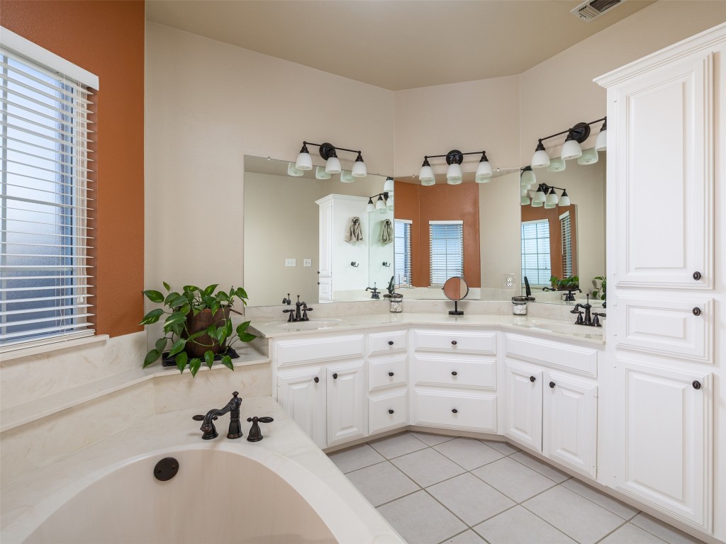 651 County Road 497 Taylor, TX 76574 - Photo 18 of 40 a bathroom with a sink vanity tub and a mirror
