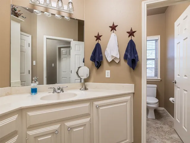 a bathroom with a sink a toilet and a mirror