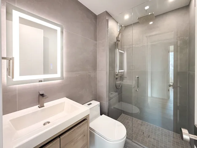 a bathroom with a sink a toilet and shower