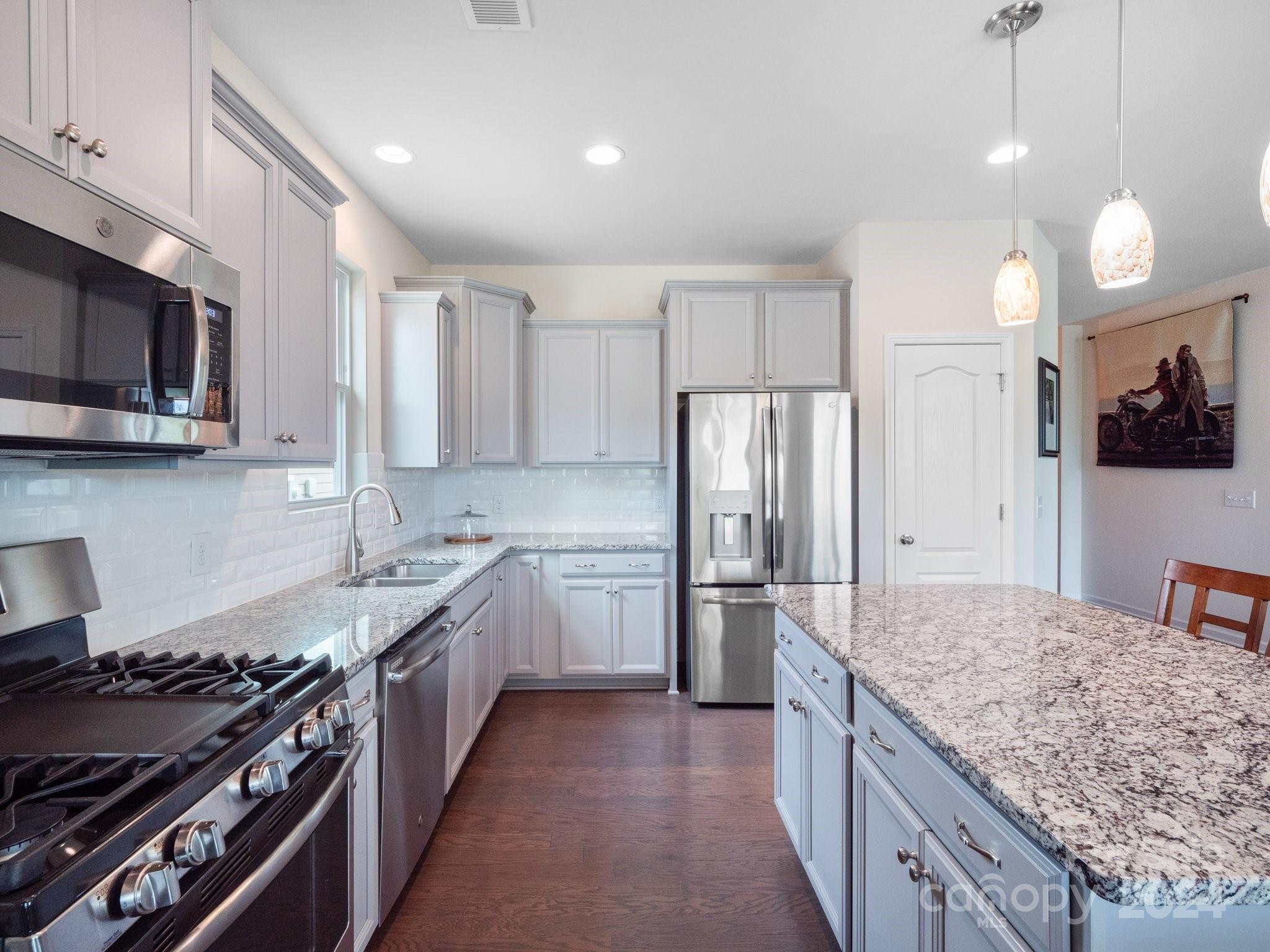4239 Merrivale Drive Lancaster, SC 29720 - Photo 12 of 33 a kitchen with stainless steel appliances granite countertop a stove a sink a refrigerator and a wooden cabinets