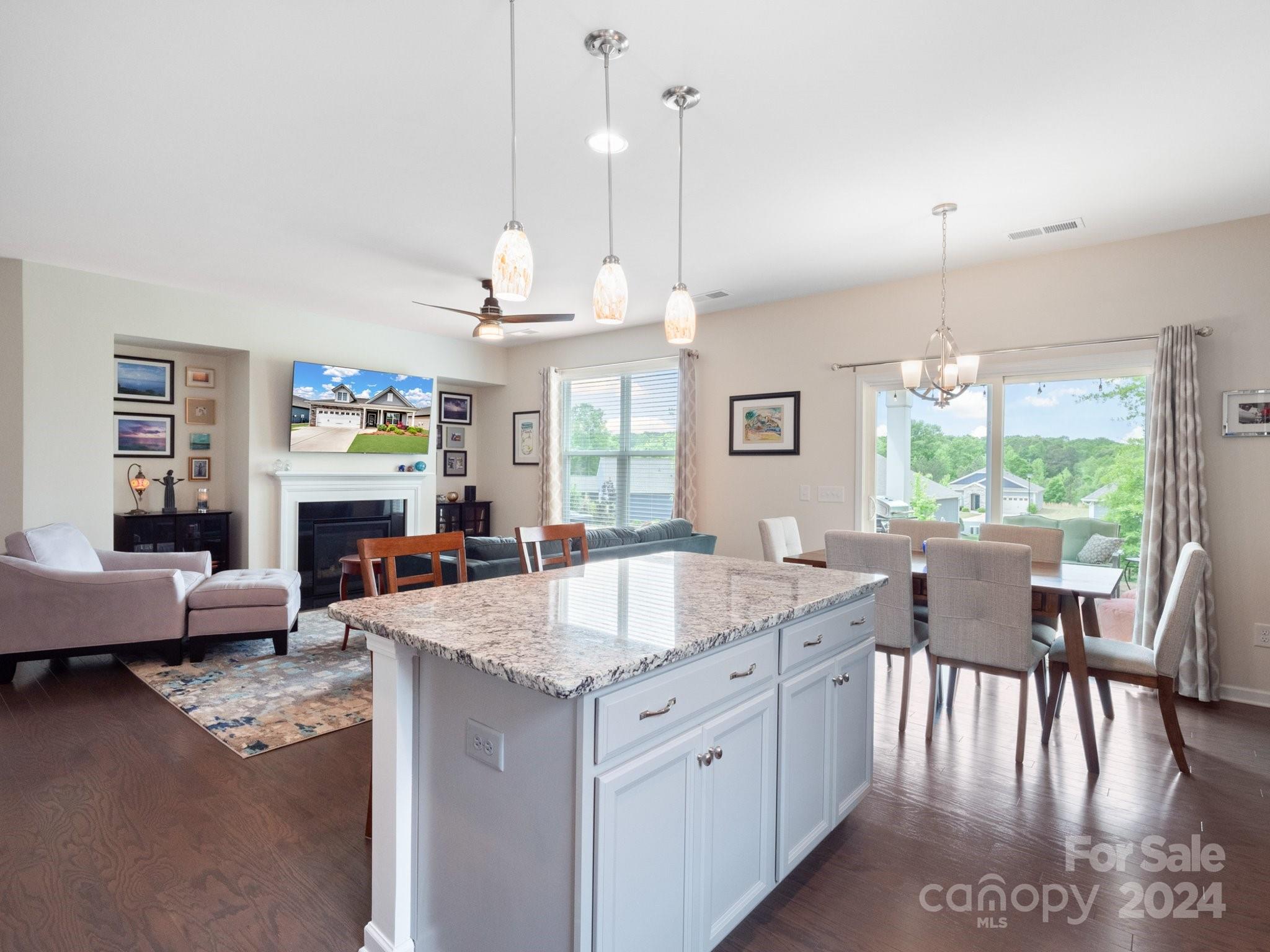 4239 Merrivale Drive Lancaster, SC 29720 - Photo 2 of 33 a large kitchen with granite countertop a stove a sink a dining table and chairs with wooden floor