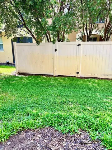 a view of a backyard with white fence