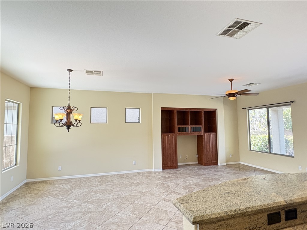 10 Caprington Road Henderson, NV 89052 - Photo 13 of 44 An inviting open-concept living area features a decorative chandelier and built-in cabinetry, all set on durable tile flooring.