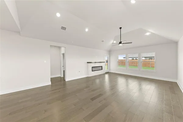 an empty room with windows and ceiling fan