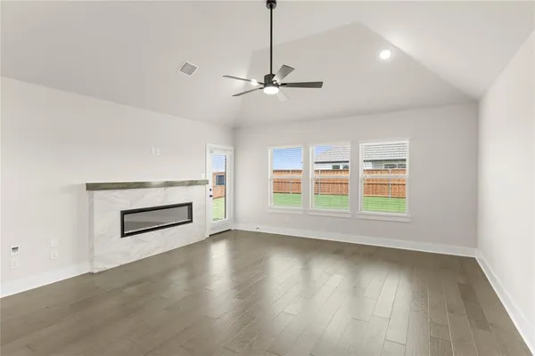 an empty room with a window and a ceiling fan