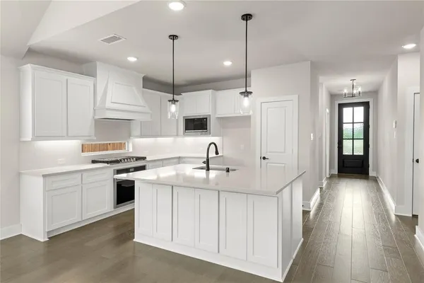 a kitchen with a sink stove and wooden floor