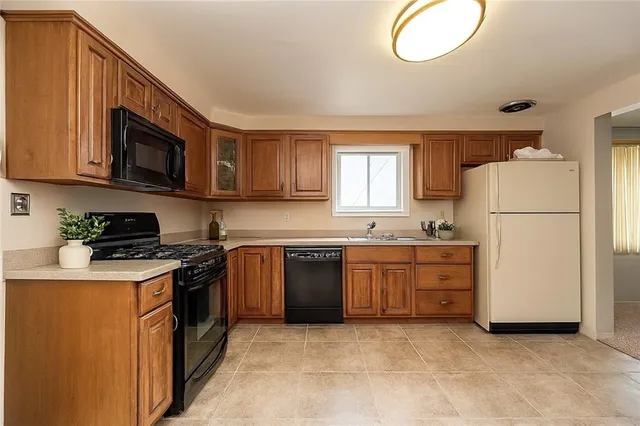 a kitchen with cabinets stainless steel appliances and a window