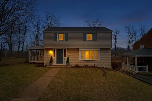 a view of playground with a slide and large trees