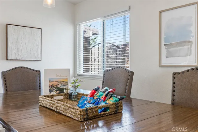 a kitchen with stainless steel appliances granite countertop a table chairs sink and cabinets