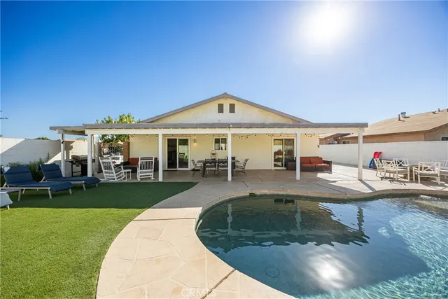 a view of a house with swimming pool and sitting area