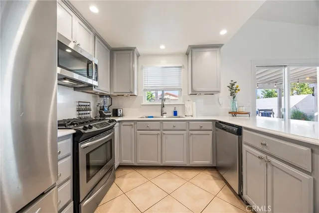 a kitchen with granite countertop a refrigerator stove and sink