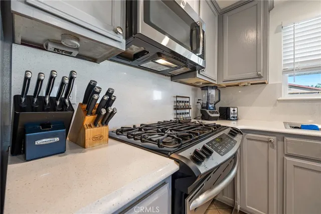 a open dining room with stainless steel appliances kitchen island granite countertop a table chairs and a microwave