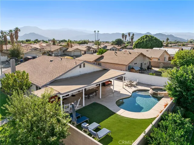 an aerial view of residential houses with outdoor space and parking