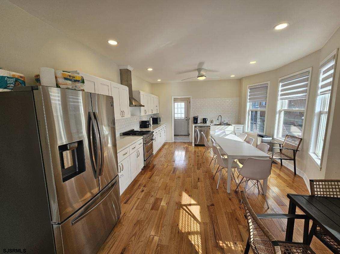 27 South Little Rock Avenue, Unit JUNE 2026 Ventnor City, NJ 08406 - Photo 21 of 91 a kitchen with stainless steel appliances a refrigerator a stove a sink a dining table and chairs