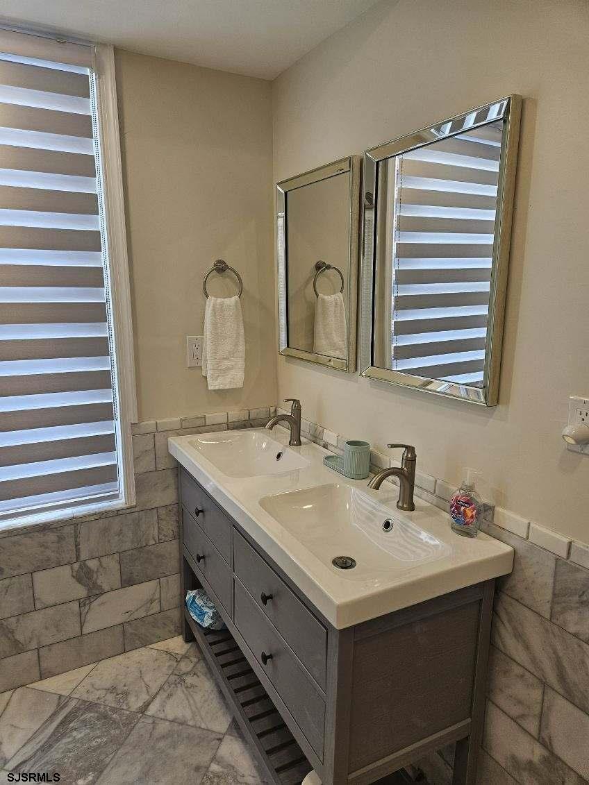 27 South Little Rock Avenue, Unit JUNE 2026 Ventnor City, NJ 08406 - Photo 26 of 91 a bathroom with a sink and a mirror