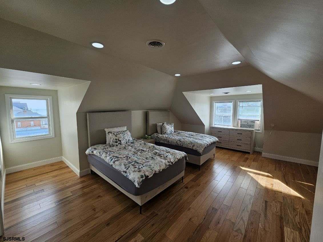 27 South Little Rock Avenue, Unit JUNE 2026 Ventnor City, NJ 08406 - Photo 43 of 91 a bedroom with a bed and wooden floor