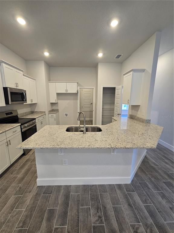 1117 Heron Point Drive Inverness, FL 34453 - Photo 8 of 19 a large kitchen with granite countertop a stove a sink and a microwave