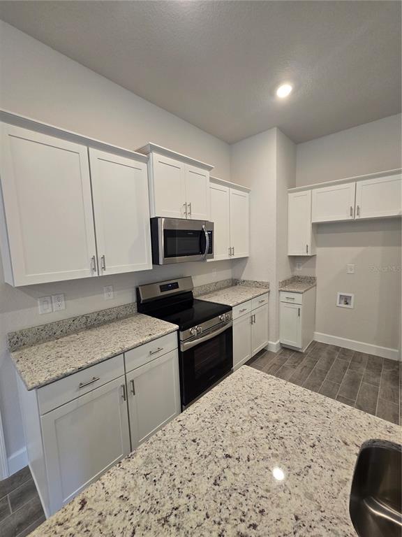 1117 Heron Point Drive Inverness, FL 34453 - Photo 9 of 19 a kitchen with white cabinets and appliances