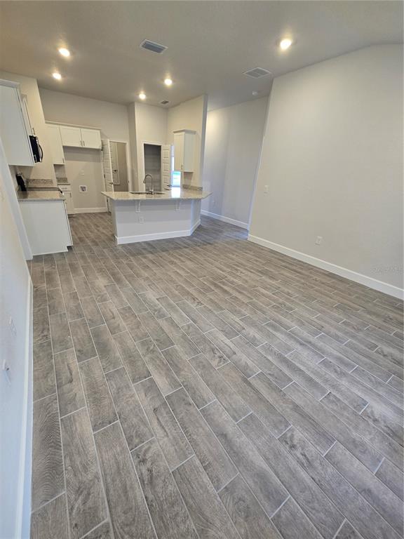 1117 Heron Point Drive Inverness, FL 34453 - Photo 10 of 19 a view of a kitchen with kitchen island a sink wooden floor and a refrigerator