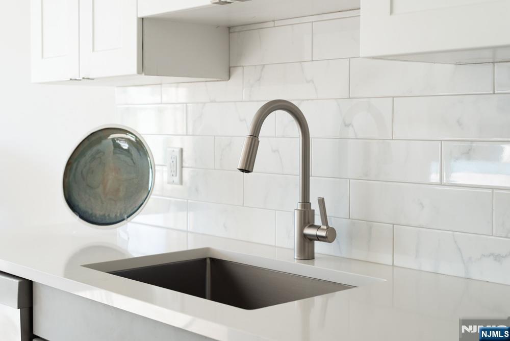 15 West Johnson Avenue, Unit 417 Bergenfield, NJ 07621 - Photo 7 of 12 a close view of a sink and a vanity in front of mirror