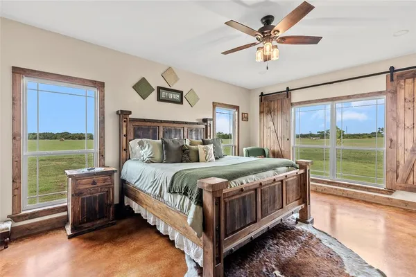 a bed sitting in a spacious bedroom next to a window