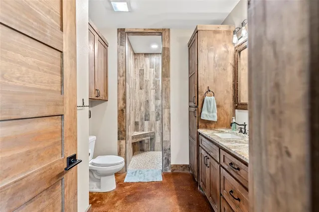 a bathroom with a granite countertop sink toilet and shower