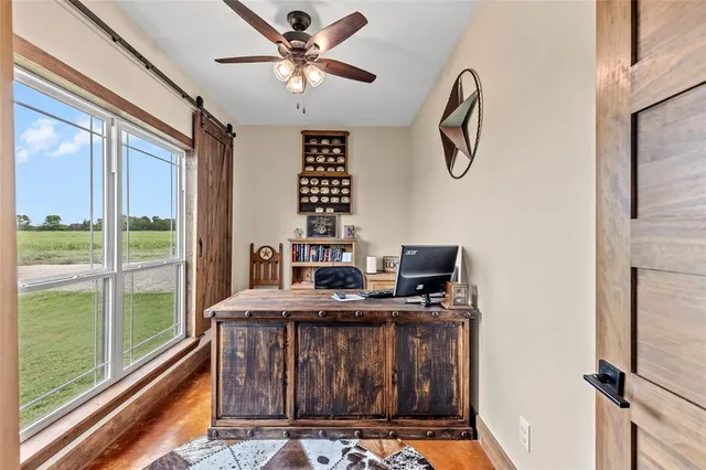 a view of a workspace with furniture and a window