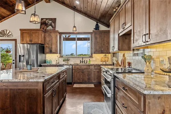 a kitchen with stainless steel appliances granite countertop a sink stove and refrigerator