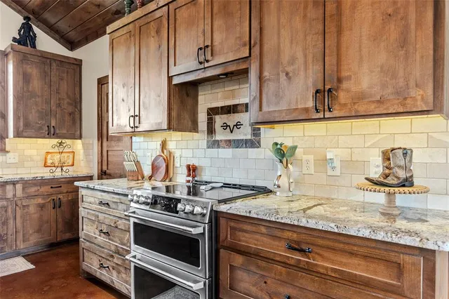 a kitchen with stainless steel appliances granite countertop a sink stove and cabinets